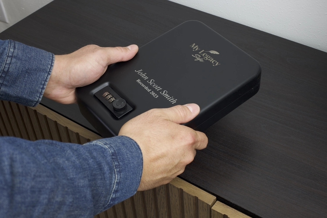 Hands holding a Legacy Safe on a desk